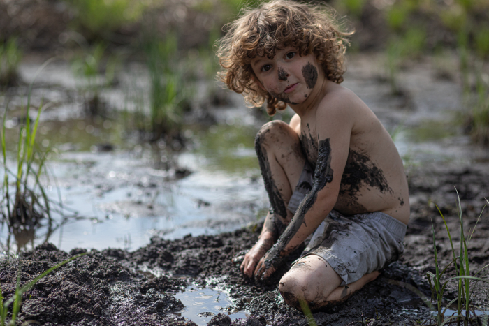 Boy playing in the mud