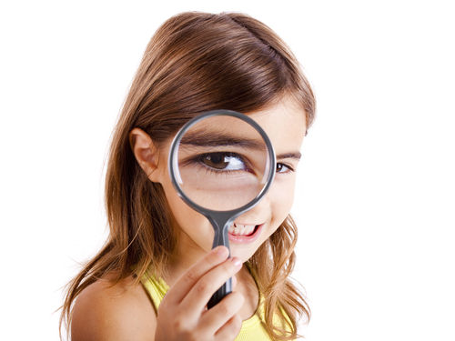 A girl looking through a magnifying glass