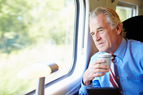 man on train holding coffee