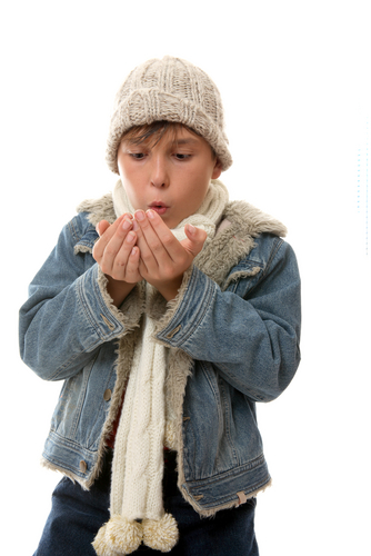 Boy blowing hands to warm up in hat and scarf