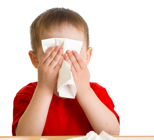 A child wiping their face with a tissue.