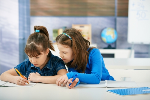 Two young girls studying together