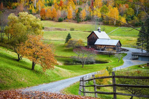 Farm barn surrounded by trees and fields in autumn