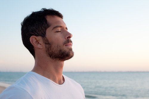 man smelling the ocean air