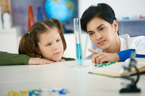 Two students looking at a measuring cylinder. 