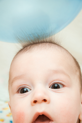image of a babies hair being attracted to a balloon. 