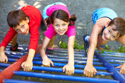 Three children climbing frame in playground