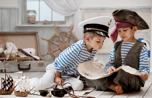 Two boys reading dressed as pirates.