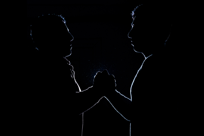 Two young men clasping hands as blood brothers