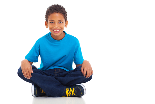 young boy sitting with legs crossed