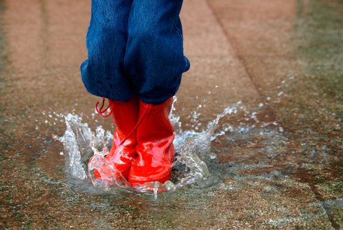boy jumping in puddle