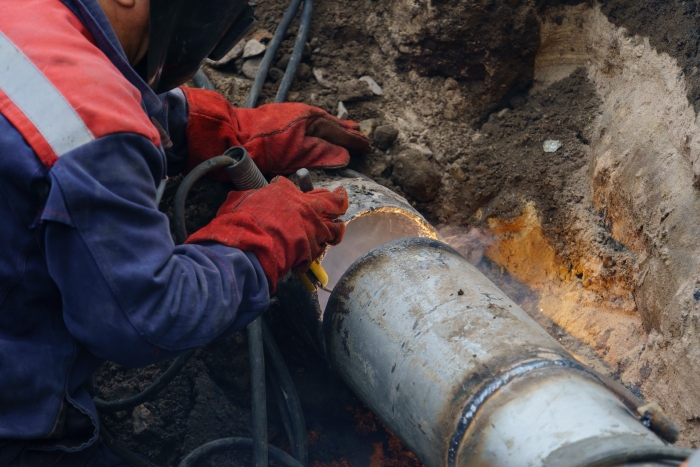 engineer mending underground pipe