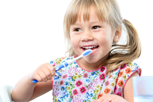 child brushing her teeth