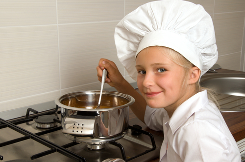 young girl cooking on stove