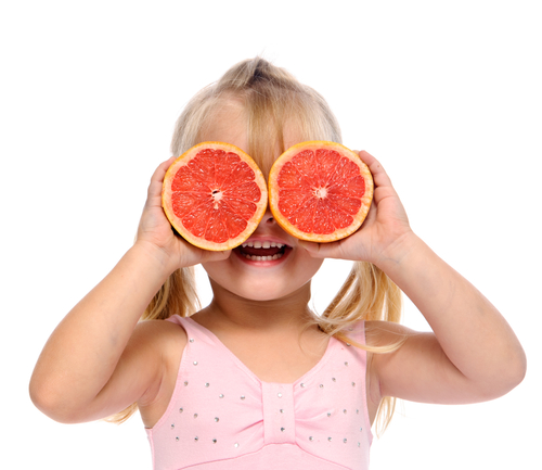 girl with grapefruit for glasses