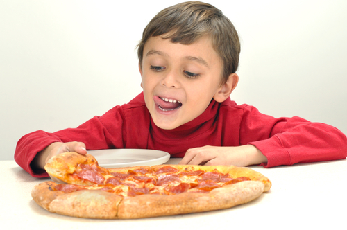 boy looking hungrily at pizza