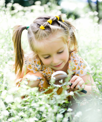 girl looking with magnifying glass