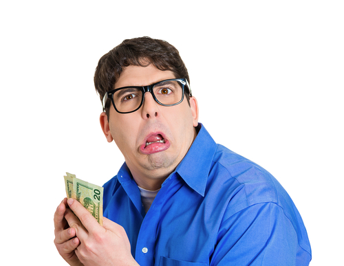 A man pulling a funny face holding American dollars