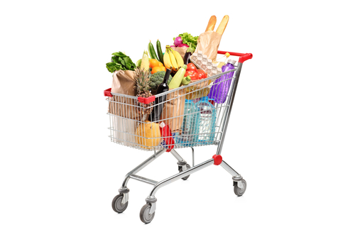 Shopping trolley full with fruit and vegetables in brown paper bags.